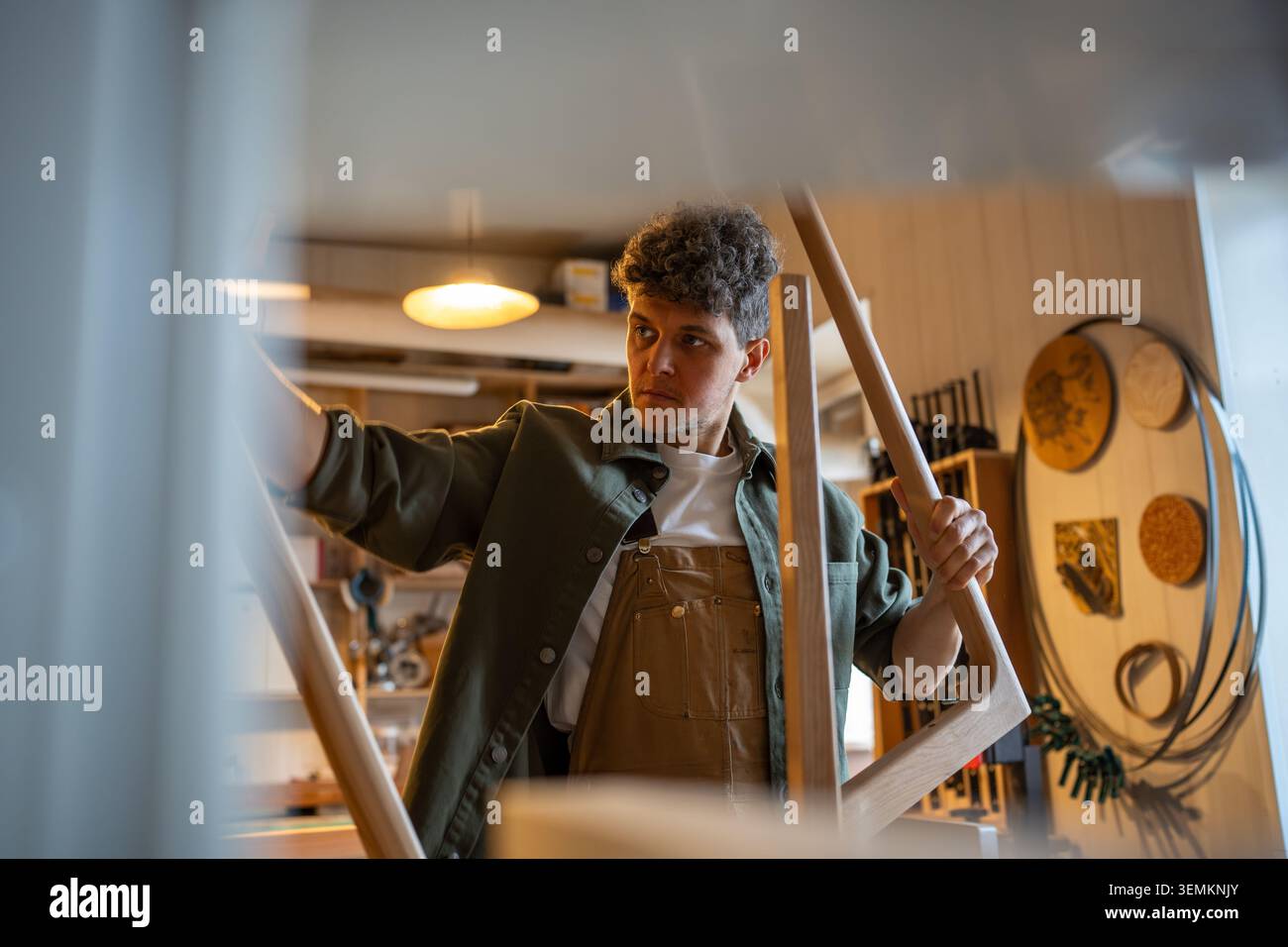 Der Handwerker überprüft Tischbeine und Sockel und stellt so eine gleichmäßige Oberfläche und eine hochwertige Konstruktion in der Werkstatt sicher Stockfoto