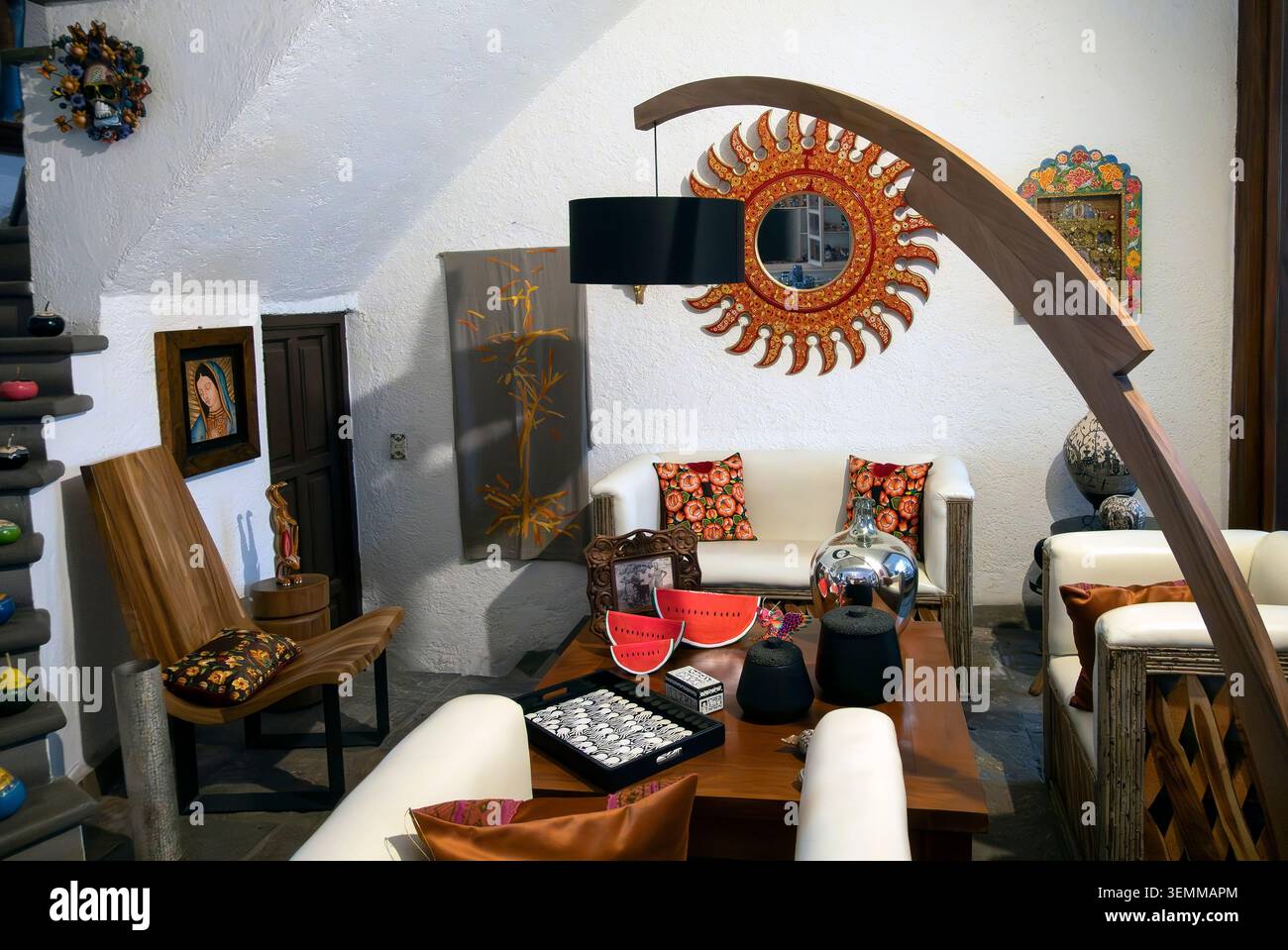 Traditionelles mexikanisches Wohnzimmer mit rustikaler Kolonialarchitektur, handwerklichem Dekor und Holzbogenlampe Stockfoto