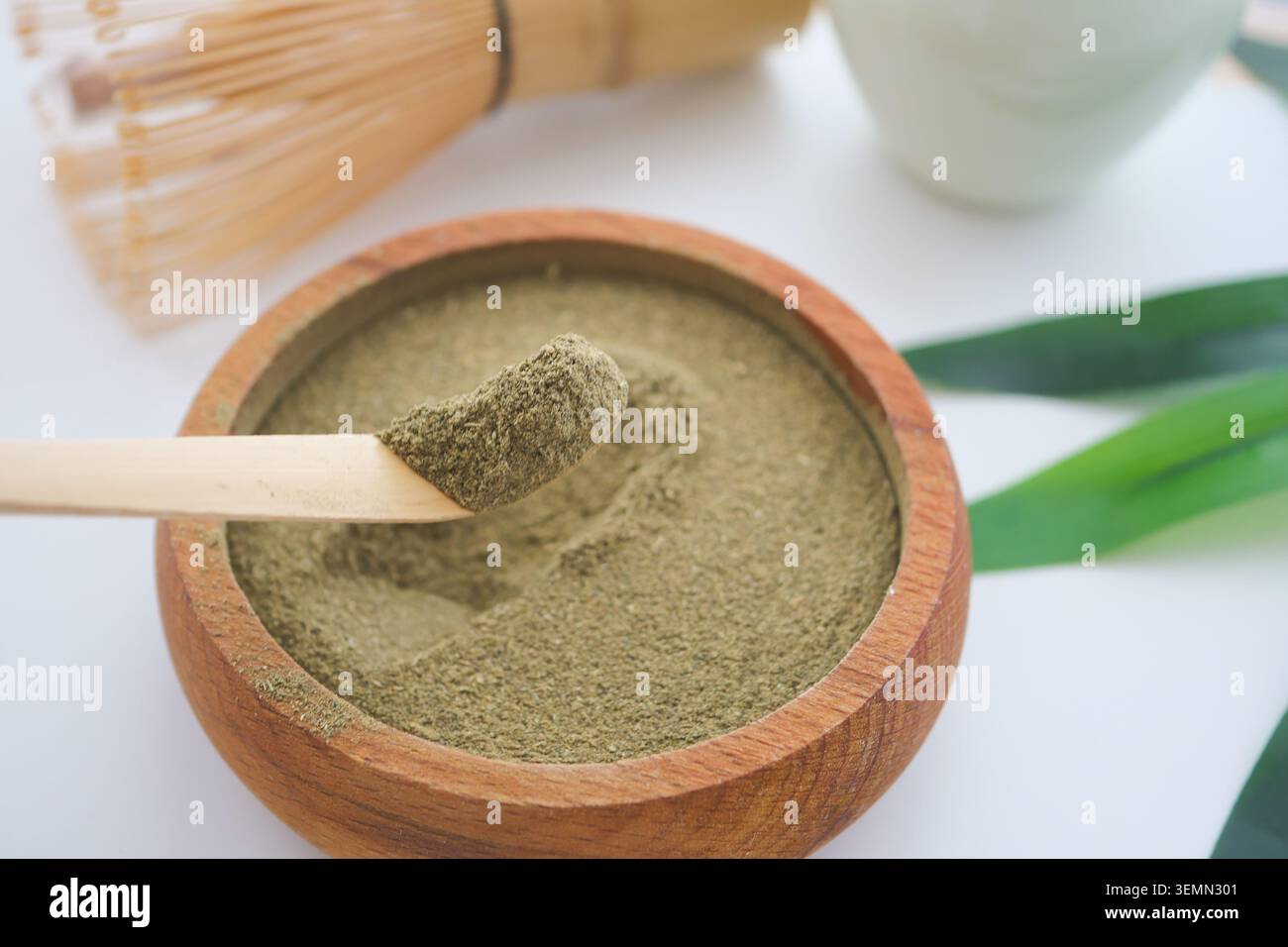 Matcha-Pulver wird aus einem Löffel in eine Schüssel gegossen Stockfoto