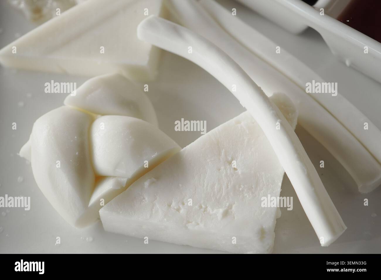 Verschiedene Käsesorten auf einem weißen Teller zum Servieren Stockfoto