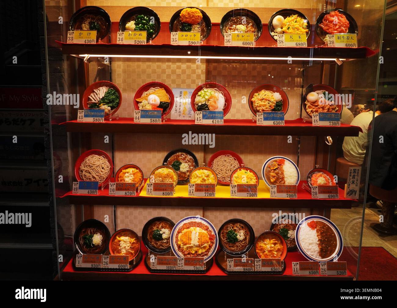 Vitrine mit japanischen Plastiknahrungsreplikaten, die Reisschüsseln, Restaurantprobenmodelle zeigen Stockfoto