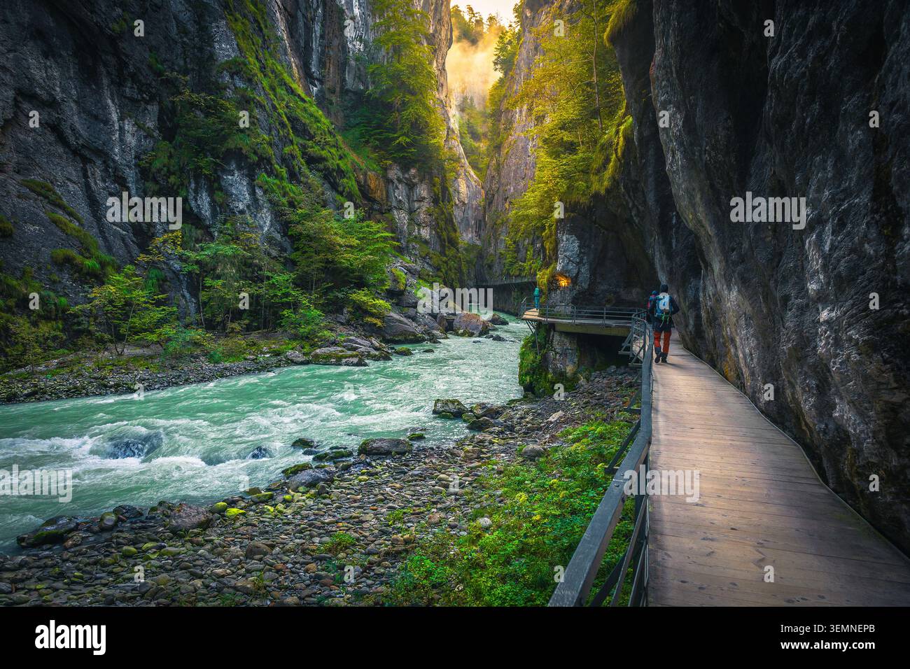 Malerisches Reiseziel und touristische Fußgängerbrücke in der Aare-Schlucht. Wanderer auf der Fußgängerbrücke über der Aare bei Sonnenaufgang, Meiringen, Schweiz, EU Stockfoto