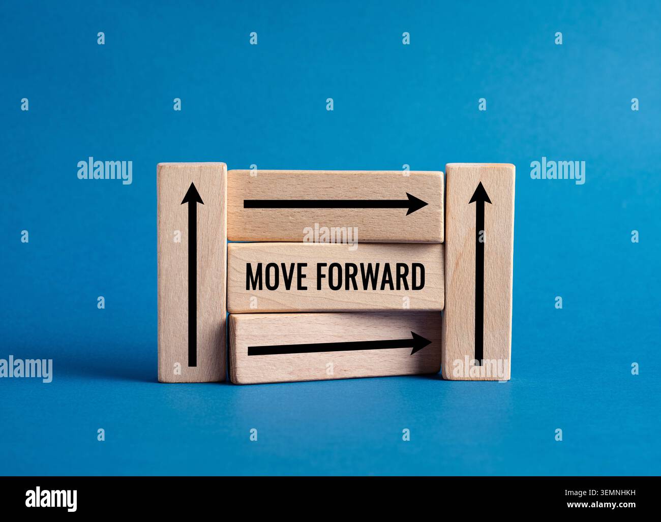 Holzblöcke mit schwarzen Pfeilen und Text BEWEGEN SICH VORWÄRTS UND symbolisieren Fortschritt, Richtung und Motivation auf blauem Hintergrund Stockfoto
