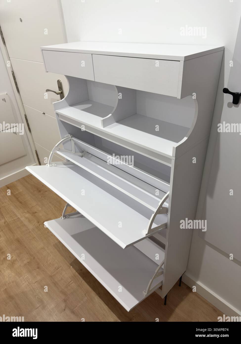 Nahaufnahme eines weißen Schuhschranks mit zwei leeren, ausklappbaren Schubladen, vollständig ausgefahren, sauberer Innenraum Stockfoto