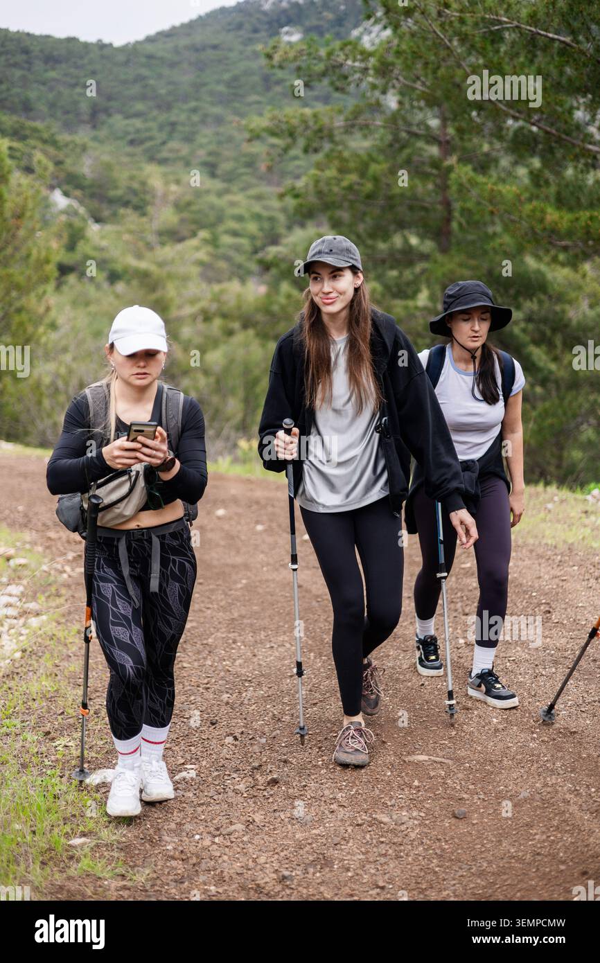 Drei Freundinnen wandern auf einem Bergweg Stockfoto