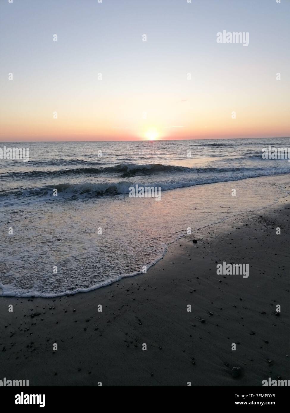 Sonnenuntergang über der Nordsee in Bjerregård, Dänemark, mit sanften Wellen, Sandstränden und farbenfrohem Abendhimmel - Smartphone-aufgenommenes Stockfoto