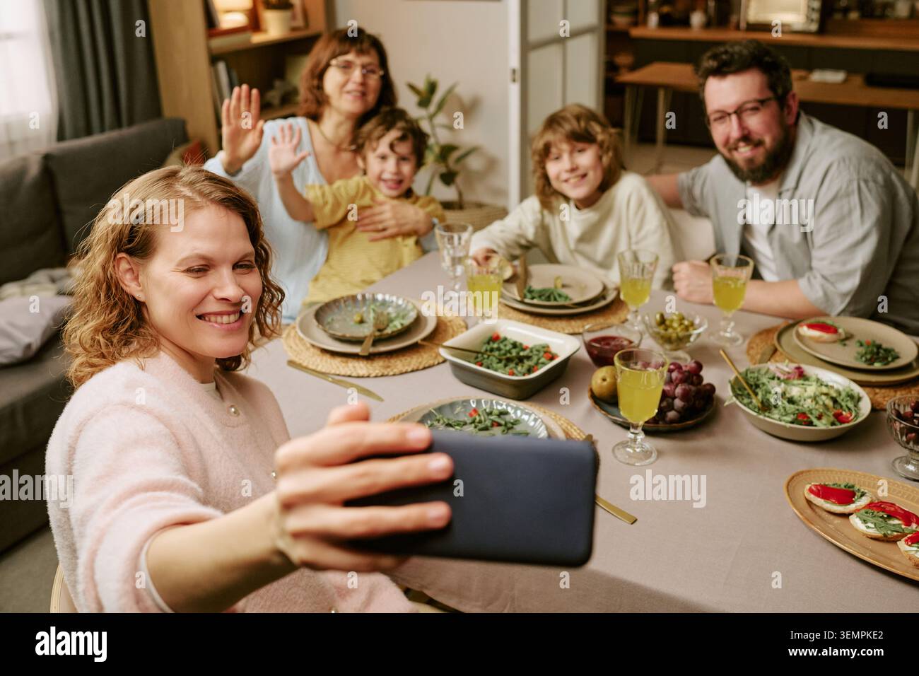 Die Familie macht ein Smartphone-Selfie während des Sonntagessens zu Hause Stockfoto