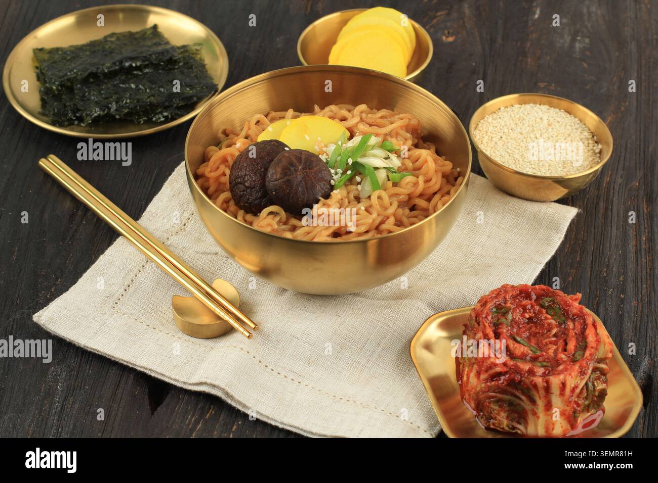 Koreanische scharfe Remayeon mit Kimchi, Nori Sheet und Danmuji Beilage. Instant Food on Gold Bowl Stockfoto