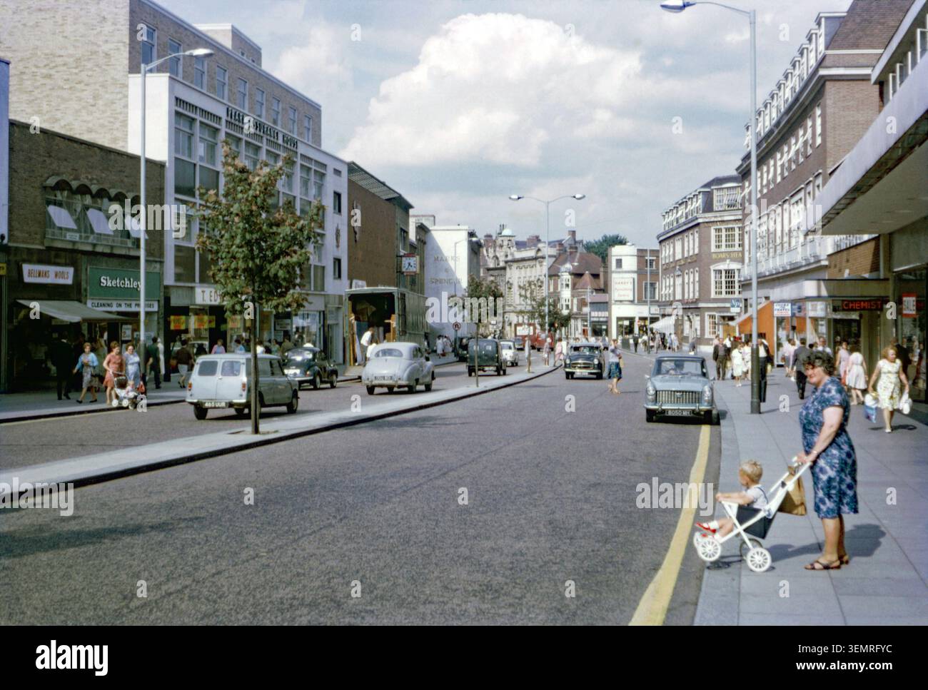 Ein Blick nach Norden entlang der St Stephens Road, Norwich, Norfolk, England, Großbritannien im Jahr 1967. Eine Frau, die einen Buggy schiebt, wartet darauf, die Straße zu überqueren. In den späten 1800er Jahren war es eine der belebtesten Straßen in Norwich. Die Straßenlandschaft veränderte sich nach schweren Schäden während der Bombenangriffe im Zweiten Weltkrieg. In der Nachkriegsregenerierung Ende der 1950er und 1960er Jahre wurde die Straße erweitert, historische Gebäude wurden durch hohe Geschäftsblöcke ersetzt und der Kreisel St. Stephen geschaffen. Heute stehen Busse und Fußgänger auf der Straße im Vordergrund. Marks & Spencer bewohnen immer noch denselben Ort wie in den 1960er Jahren Stockfoto