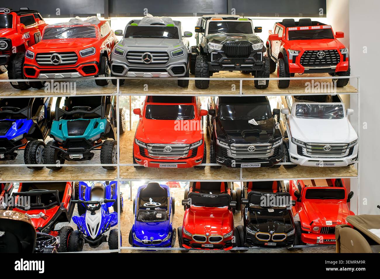 Batumi, Georgia – 3. Juni 2026: Reihen batteriebetriebener Elektrowaagen-Nachbildungen von Toyota, Mercedes und BMW auf Holzständer. Stockfoto