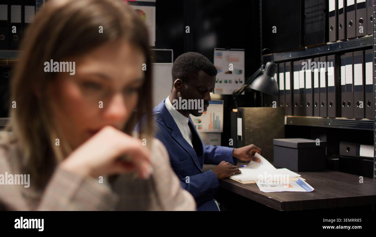Der afroamerikanische Detective bittet um einen forensischen Bericht und verdächtige Informationen von einer Privatdetektivin. Stockfoto