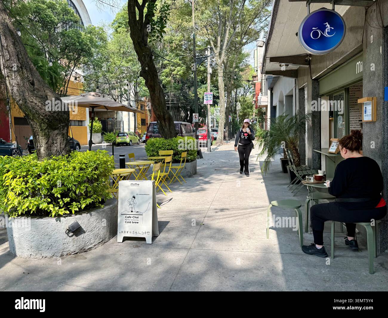 Ein kleines Straßencafé in einer grünen Straße in Roma Sur, Mexiko-Stadt. Stockfoto
