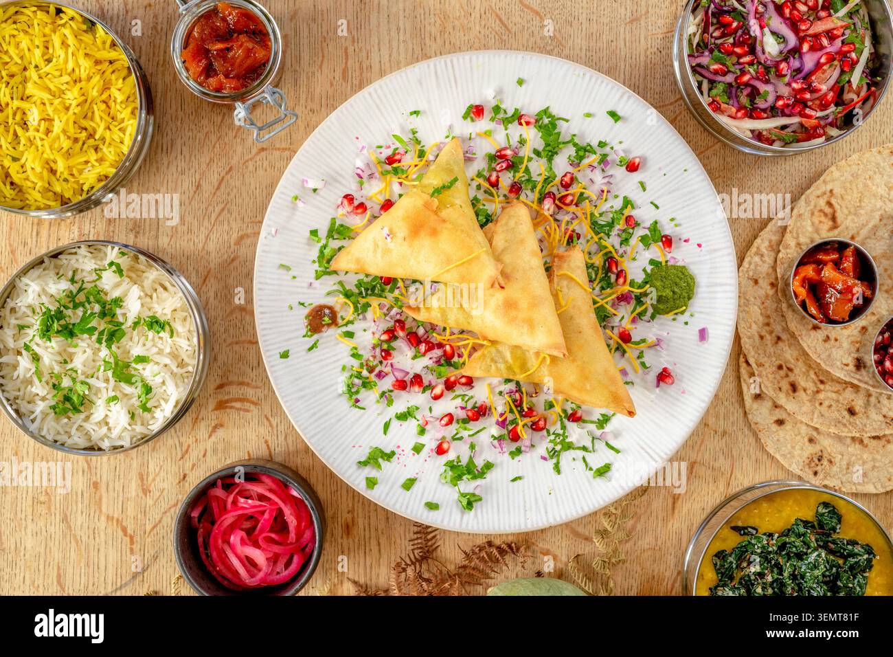Köstliche indische Küche mit farbenfrohen Samosas und lebhaften Beilagen Stockfoto