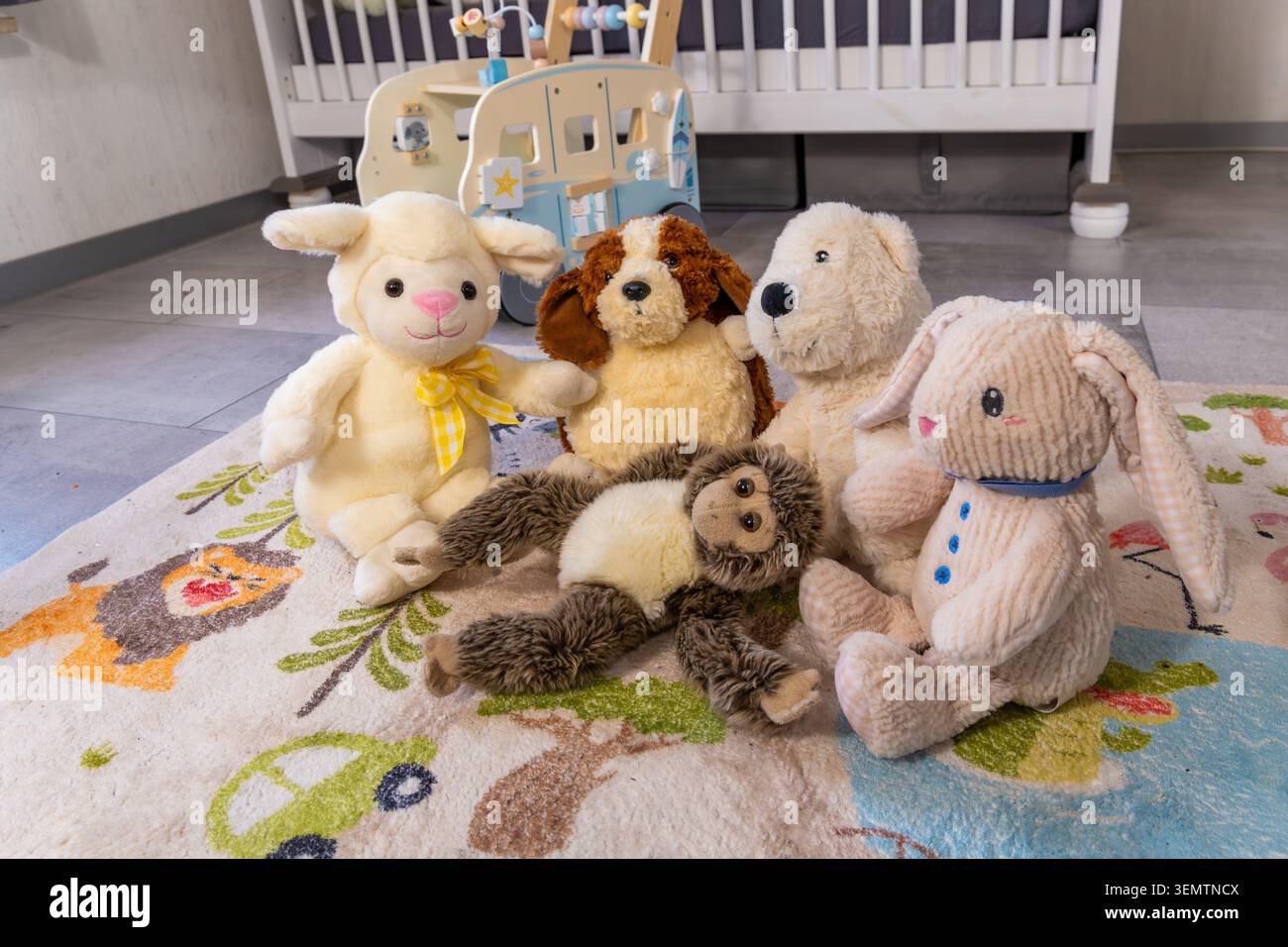 Eine Sammlung niedlicher Plüschtiere auf einem farbenfrohen Kinderteppich in einem gemütlichen Kinderzimmer oder Spielzimmer. Die Kuschelspielzeuge, darunter ein Häschen, ein Hund, bea Stockfoto