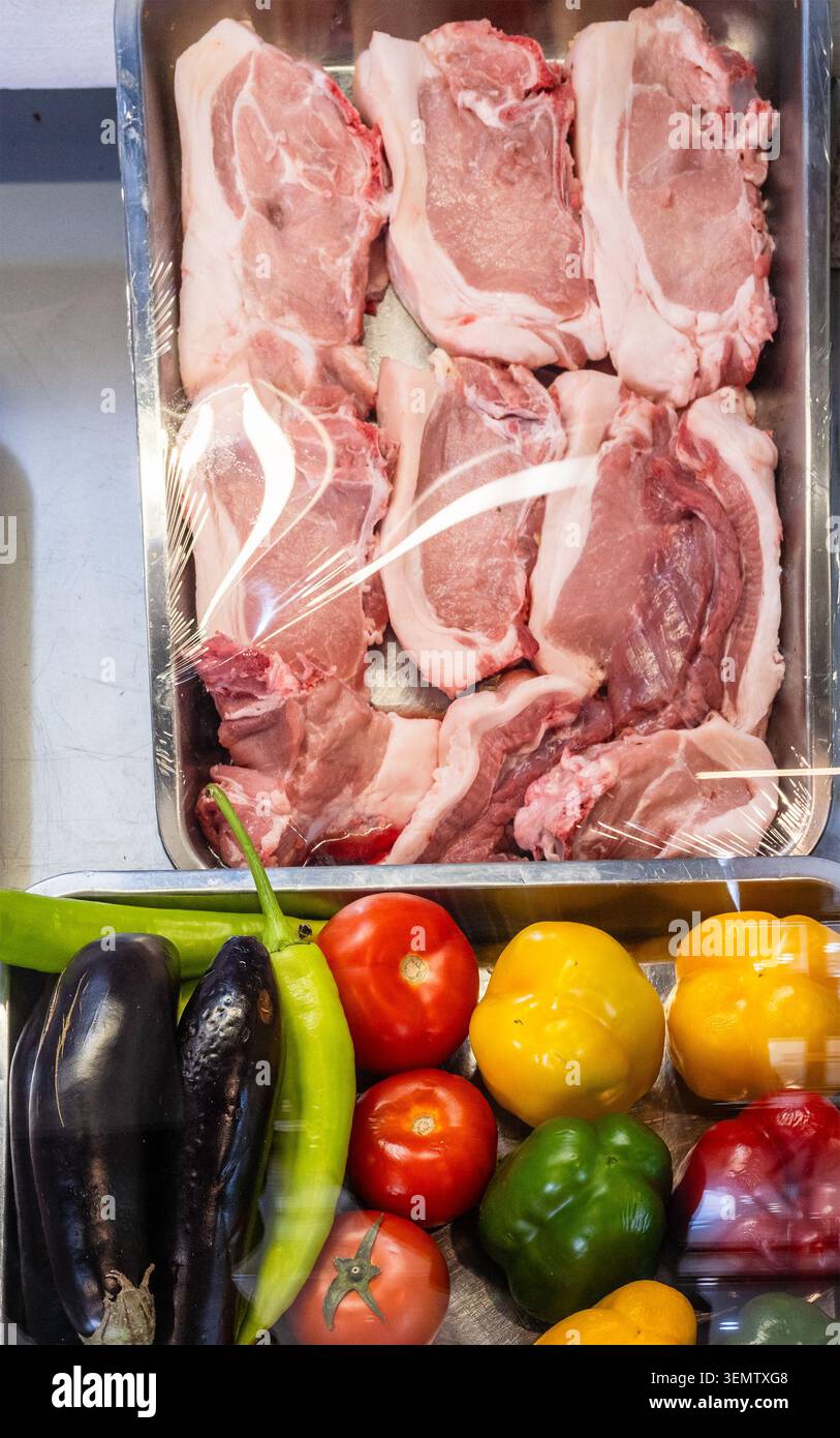 Tablett mit rohen Schweinekoteletts und lokalem Gemüse, das im Straßencafé in Armenien gegrillt werden kann Stockfoto