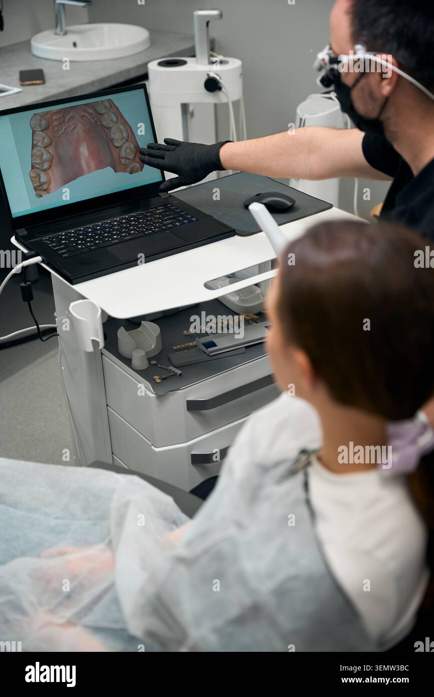 Ernsthafte Erwachsene diskutieren Zahntechnik in der modernen Klinik Stockfoto