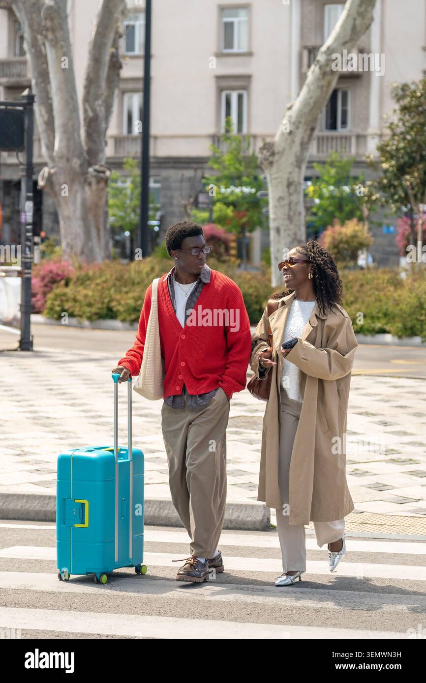 Happy verheiratete afroamerikanische Mann und Frau lächelte und redete, während sie durch die Straße gingen Stockfoto