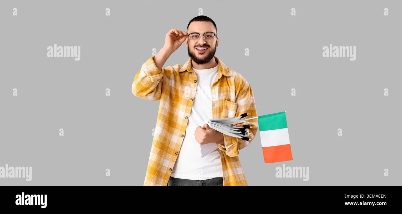 Lächelnder Mann mit irischer Flagge und Dokumenten, Bildungs- und Einwanderungskonzept, kultureller Austausch und internationale Studien Stockfoto