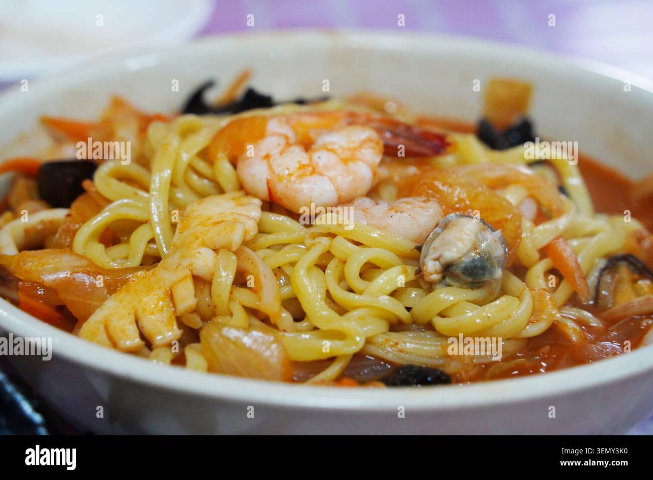 Traditionelles koreanisches chinesisches Gericht Jjampong mit scharfer roter Brühe und Gemüse Stockfoto