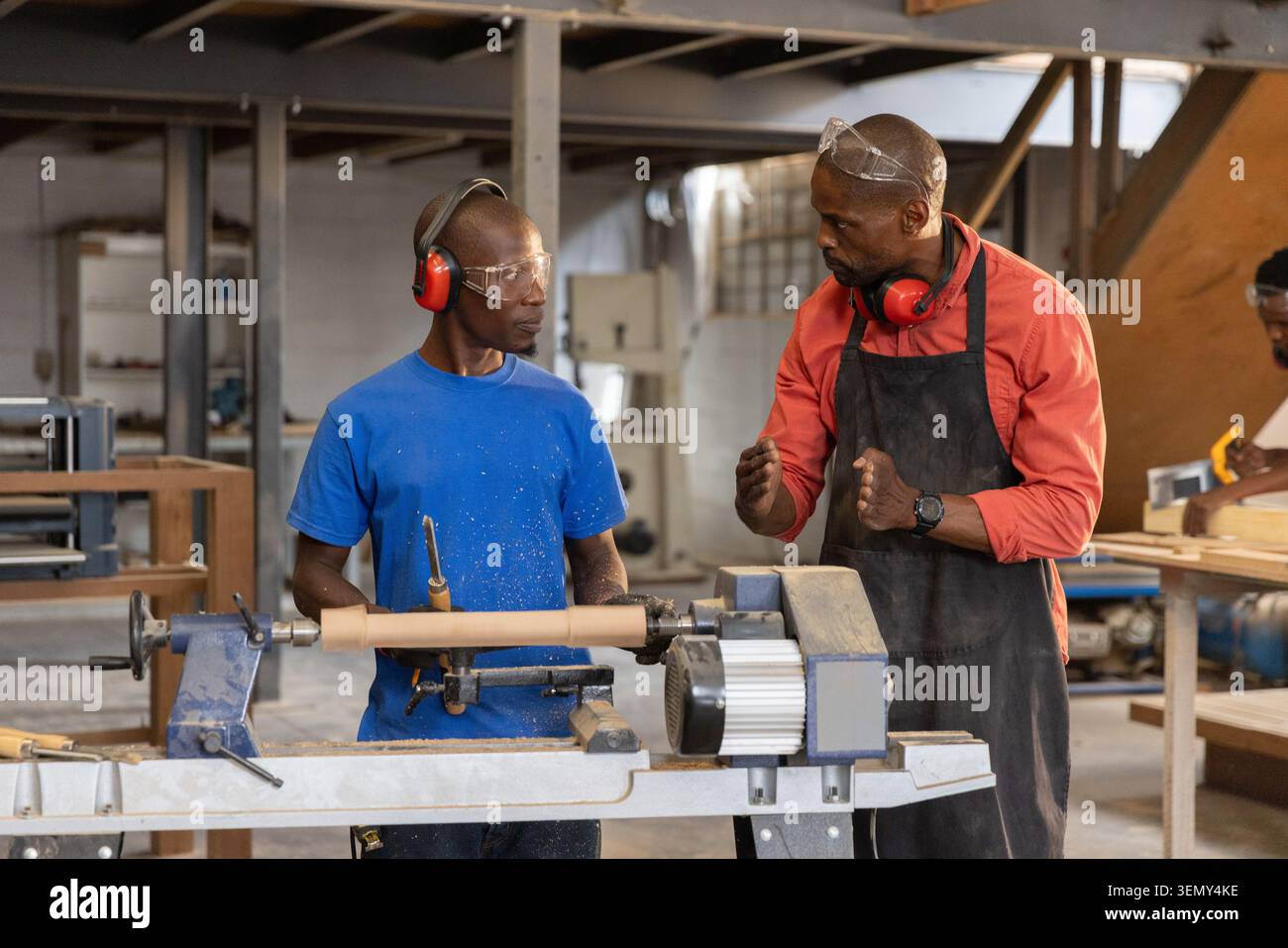 Afroamerikanischer Mentor und Lehrling Drehen von Drehrohling mit Werkzeug in der Holzwerkstatt Stockfoto