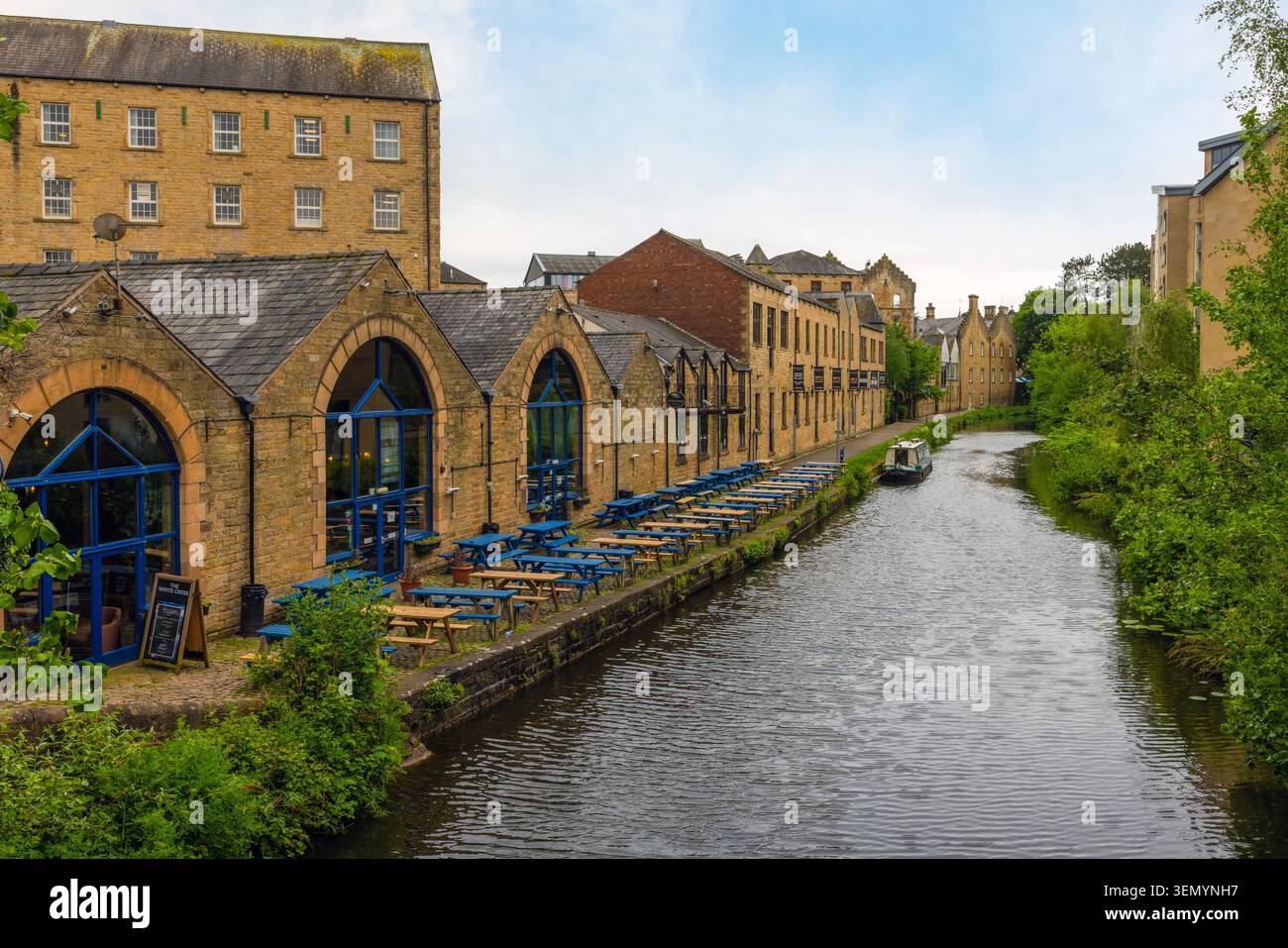 Ruhige Gewässer und Schmalboote auf dem historischen Lancaster Canal, der durch Lancaster City in Lancashire, England fließt. Stockfoto