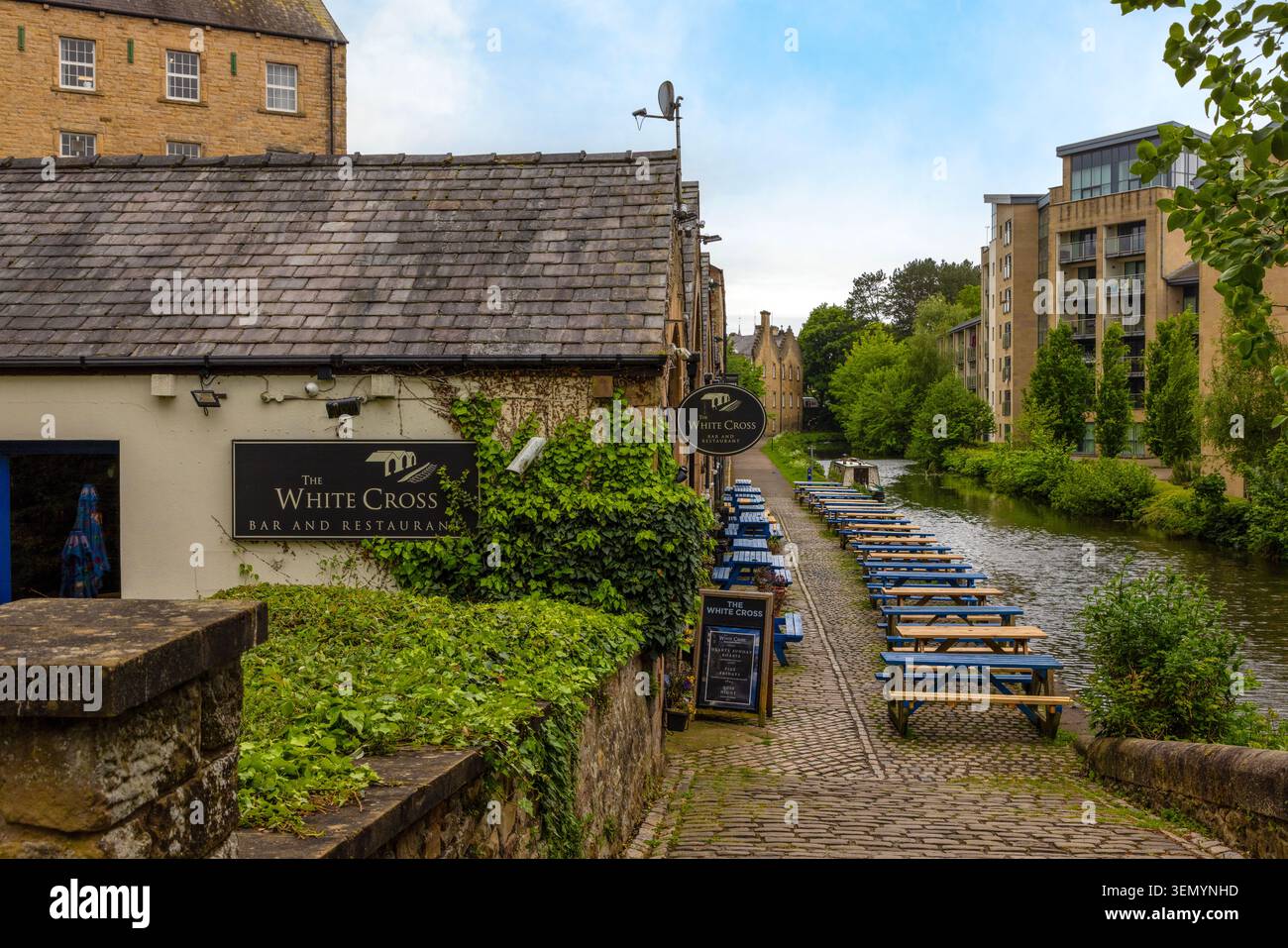 Ruhige Gewässer und Schmalboote auf dem historischen Lancaster Canal, der durch Lancaster City in Lancashire, England fließt. Stockfoto