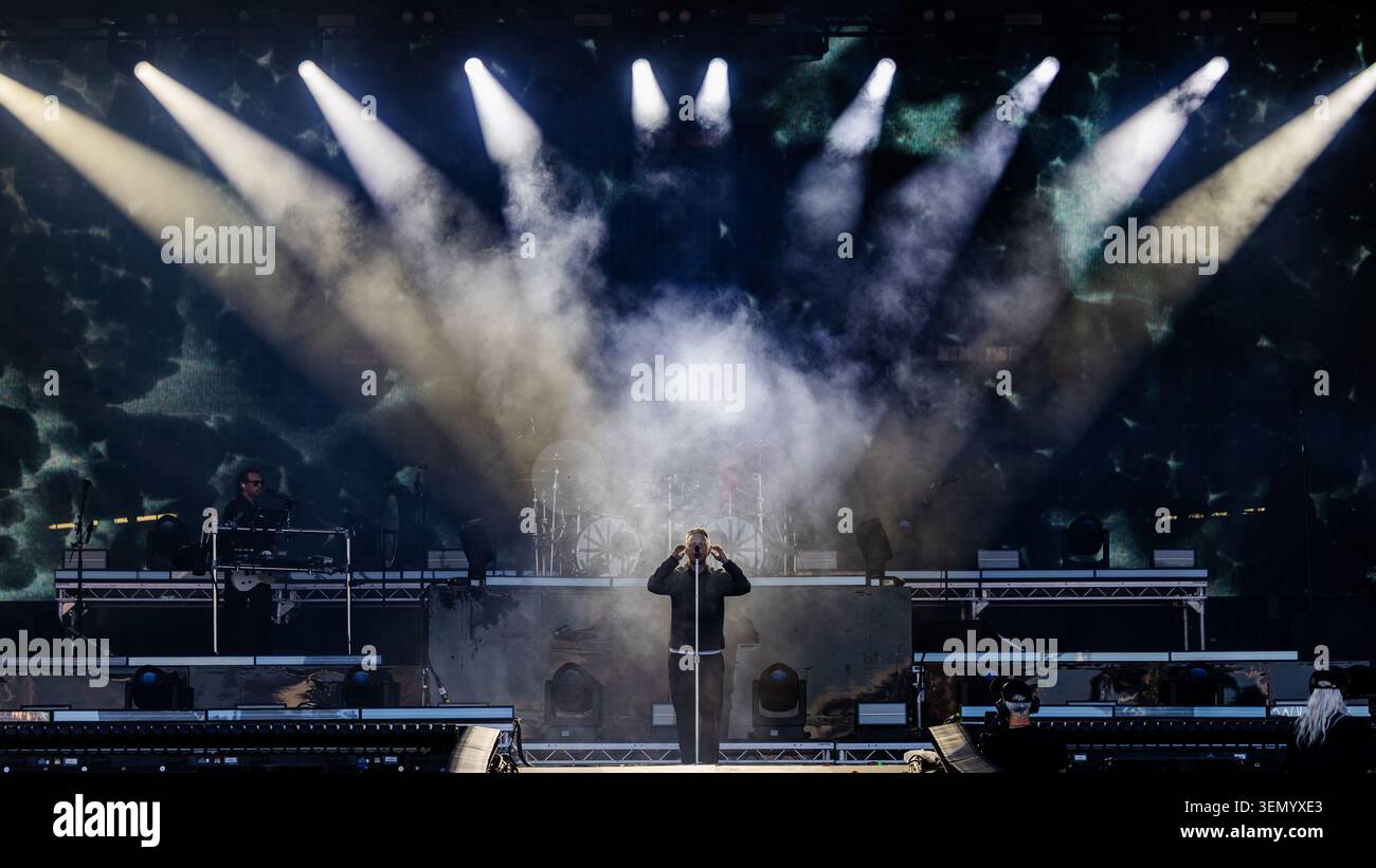 Sam Carter, Saenger der britischen Metalcore-Band ARCHITECTS, steht an einem Mikrofonstaender auf der Buehne. Buehnenshow mit Nebelmaschine, Scheinwerferlicht und grossflaechiger LED-Videowall im Hintergrund. Musikfestival Rock im Park 2026 - ARCHITEKTEN, Nürnberg, 07.06.2026 Foto: Eibner/Ardan Fuessmann Stockfoto