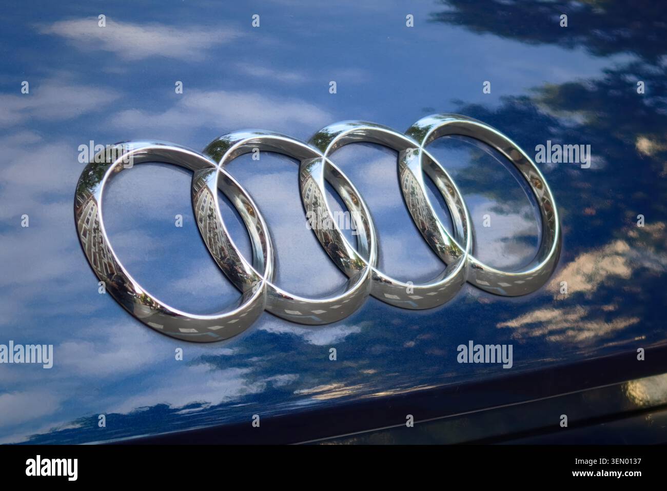 Logo der Audi Metallic Ringe auf blauer Fahrzeugaußenseite Stockfoto