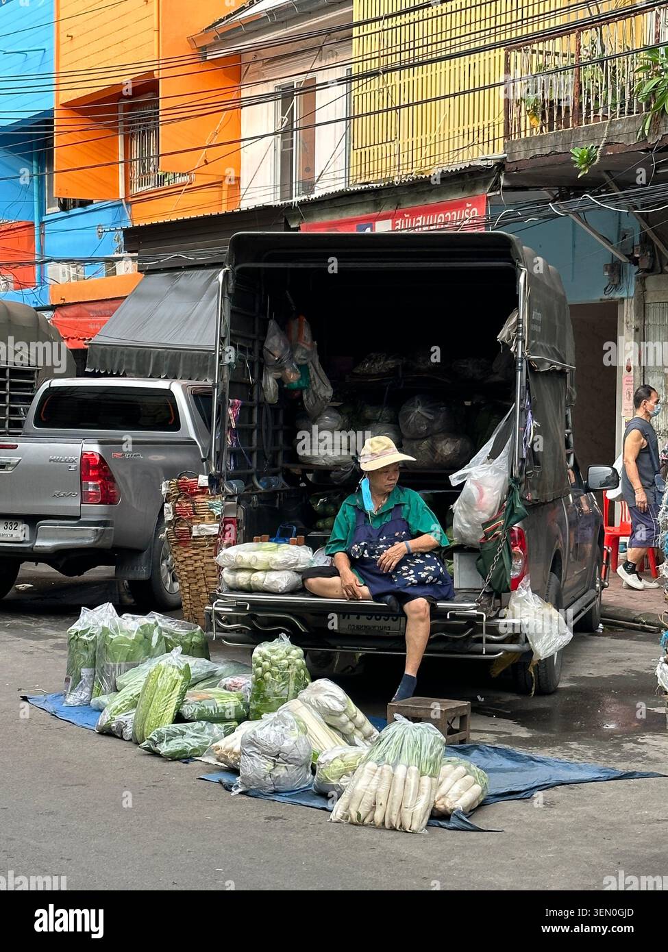 Gemüse auf Rädern: ein Straßenhändler verkauft frische Grünpflanzen vom Heck eines Pickups aus, Bangkok, Thailand - Smartphone-aufgenommenes Stockfoto