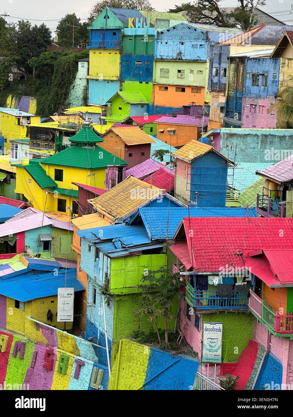 Malkunst: Ein Hügel regenbogenfarbener Häuser stürzt sich den Hang von Kampung Warna-Warni Jodipan, Malang, Indonesien hinab - Smartphone-aufgenommenes Stockfoto