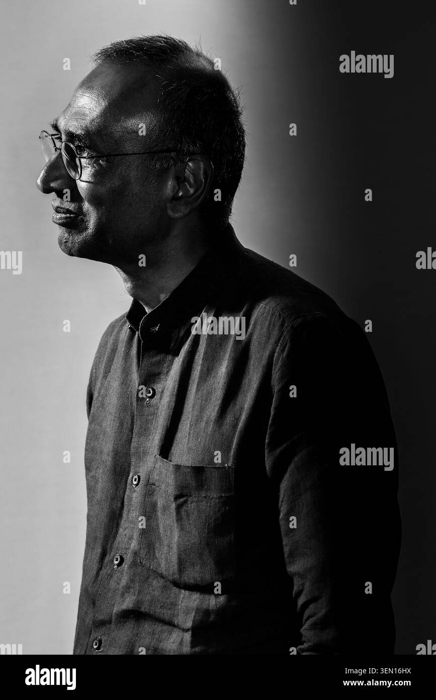 Ein Mann steht im Profil mit einem nachdenklichen Blick im Gesicht. Er ist in einem schattigen Bereich mit sanfter Beleuchtung. Die Einstellung erzeugt einen starken Kontrast, der stark ist Stockfoto