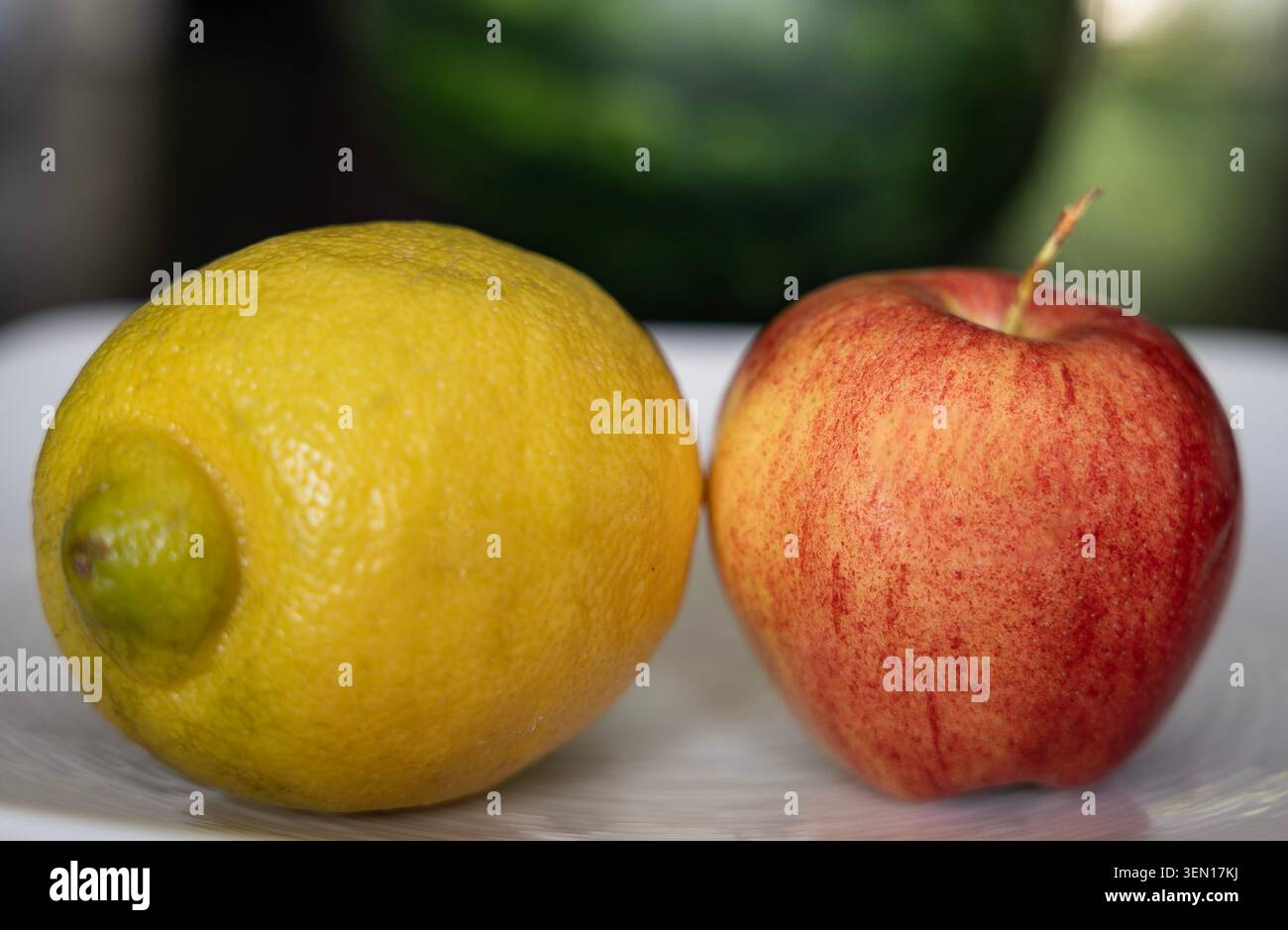 Eine Zitrone und ein Apfel auf einer weißen Oberfläche Stockfoto
