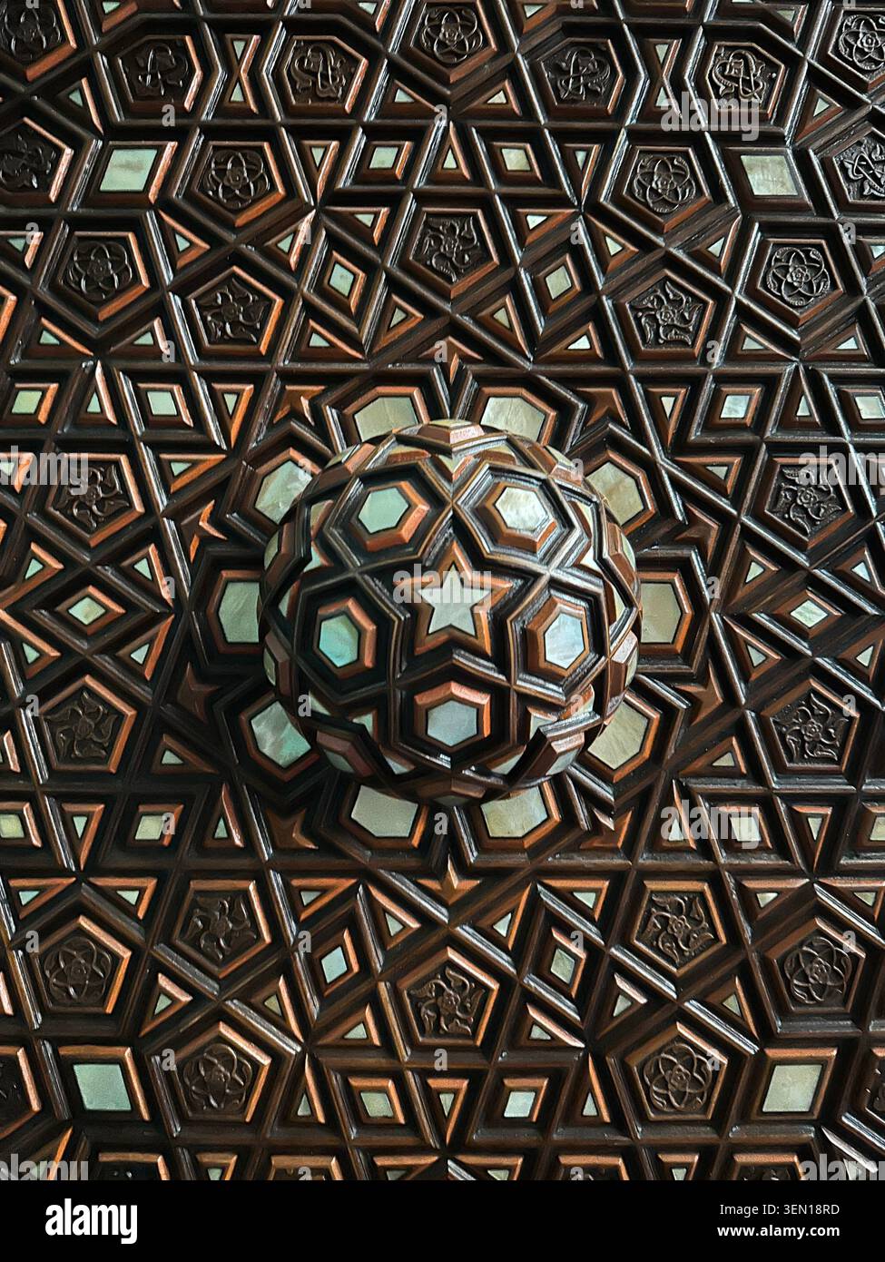 Die geometrische Deckenrosette aus Holz verwandelt das Handwerk im osmanischen Stil in ein hypnotisches Mosaik mit Sternenmuster Stockfoto
