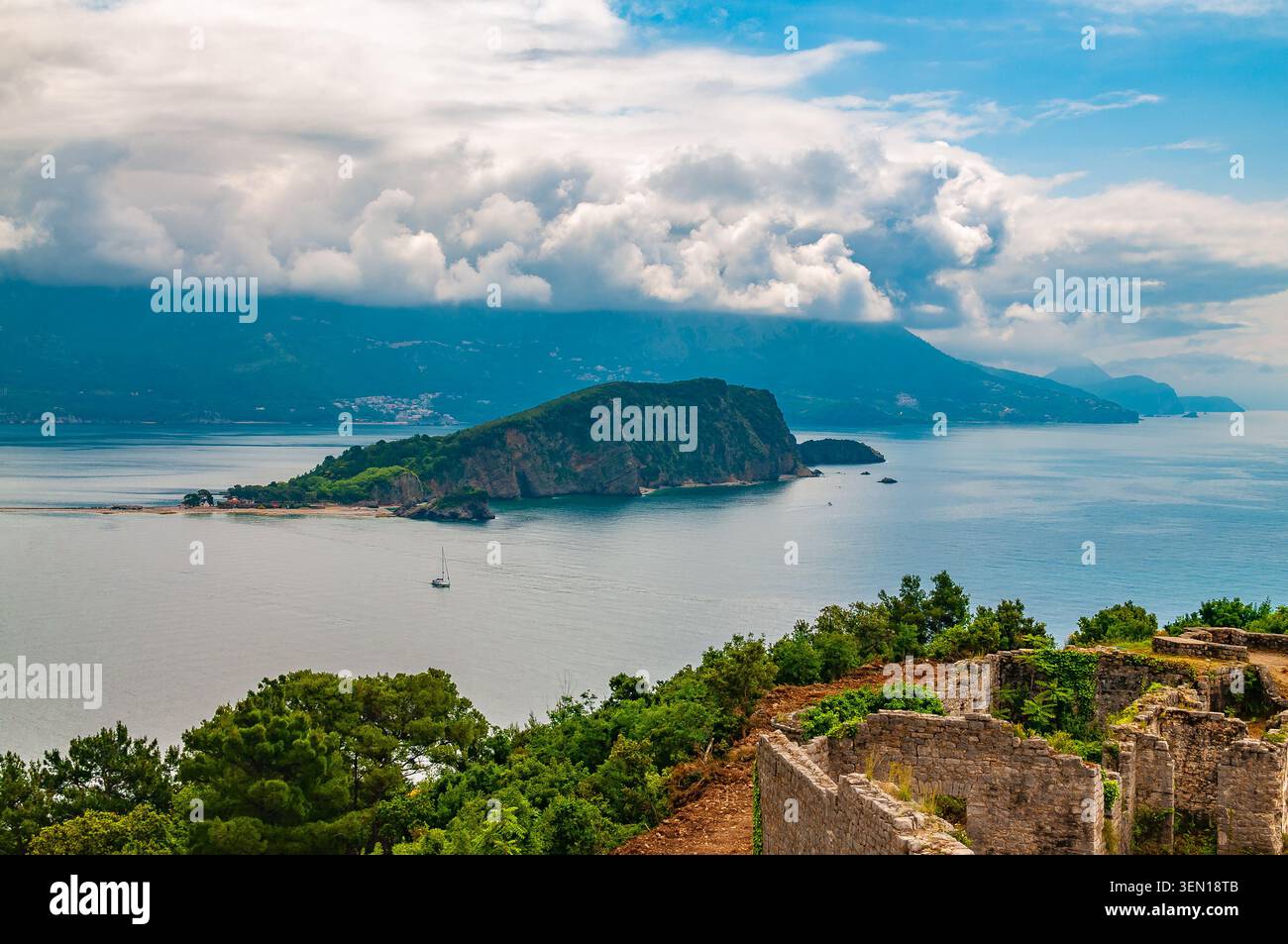 Blick auf die Insel St. Nikolaus in Budva, umgeben von der klaren Adria, mit den antiken Steinruinen der Festung Mogren Stockfoto