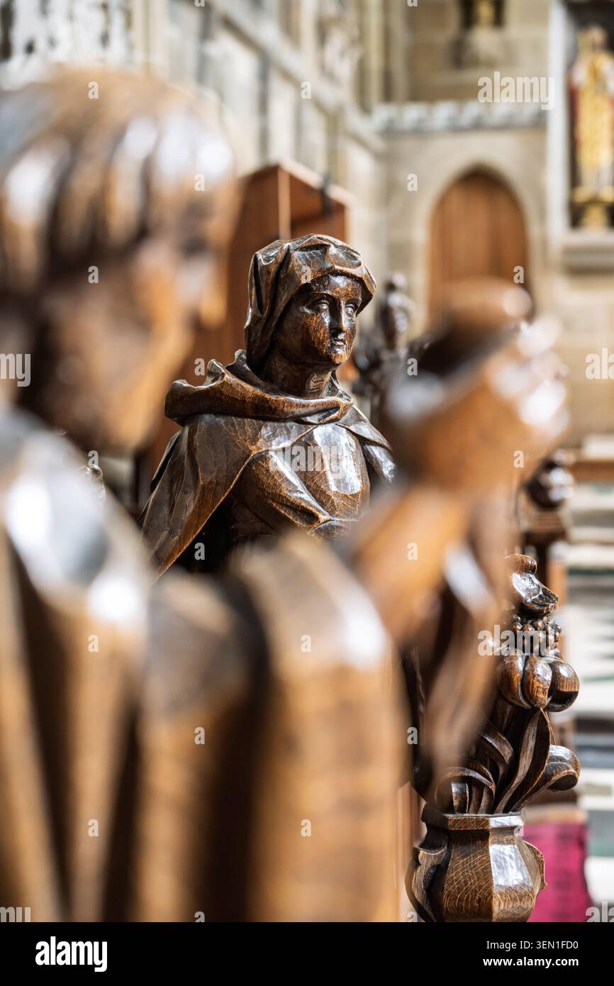 Nahaufnahme-Komposition mit Schwerpunkt auf dem ausdrucksstarken Gesicht und den Details einer historischen Holzstatue, die in den Chorständer der Kirche in Tideswell geschnitzt wurde Stockfoto