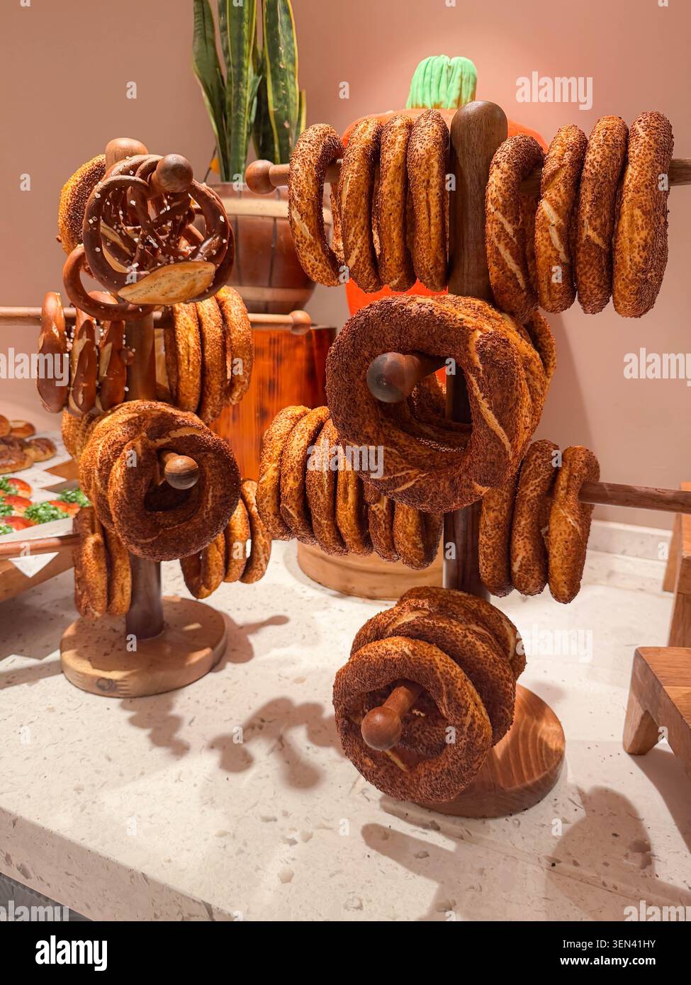 Holzständer mit Sesambagels und Brezeln auf einer Arbeitsplatte Stockfoto