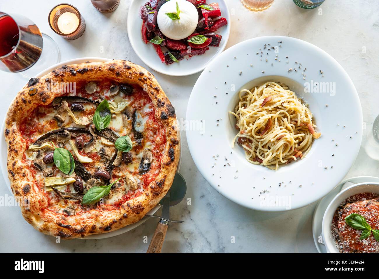 Genießen Sie köstliche italienische Küche mit Pizza und Pasta in einem gemütlichen Restaurant Stockfoto
