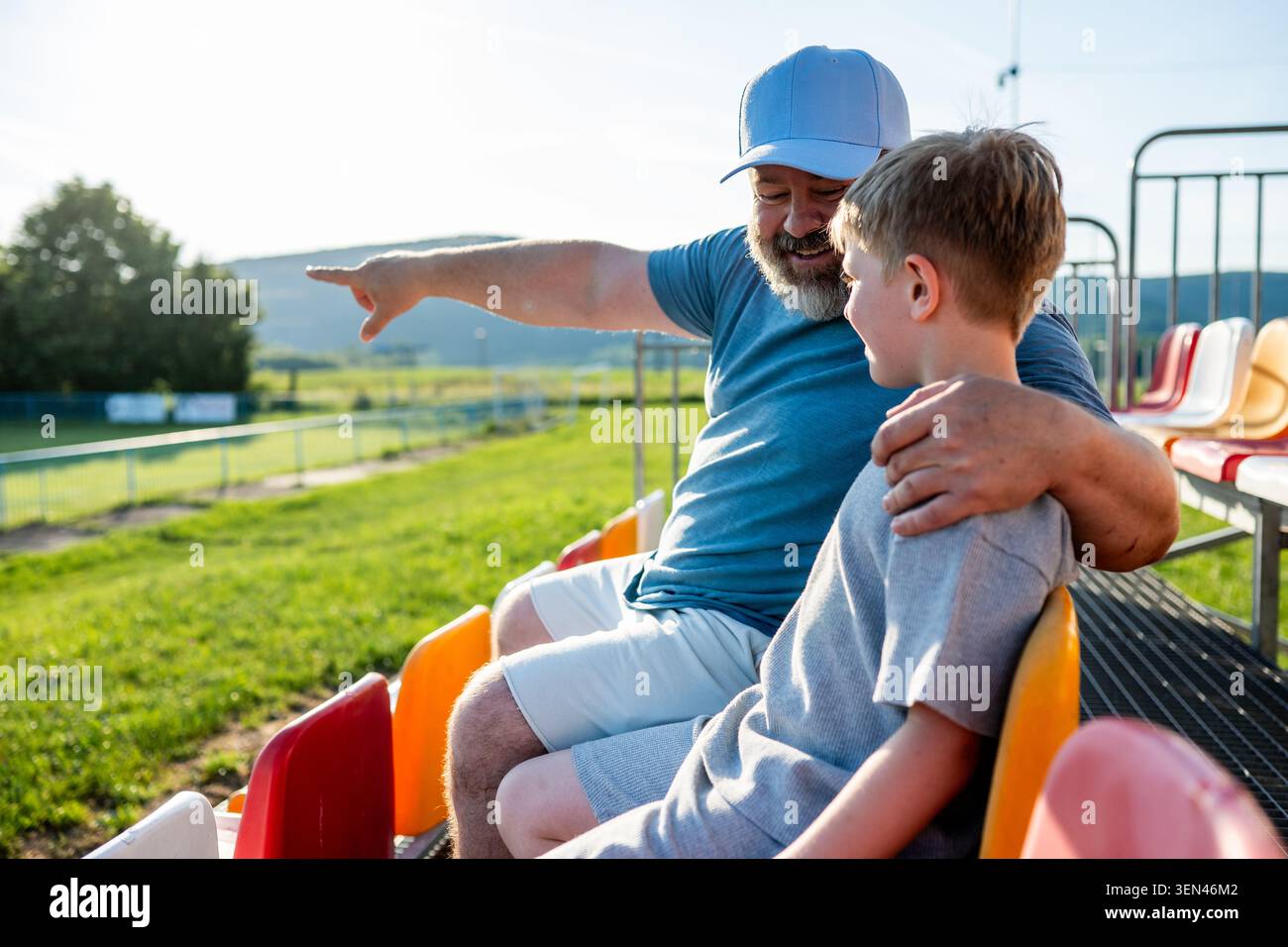 Vater und Sohn feuern die Fußballmannschaft während des Spiels im Stadion an. Stockfoto