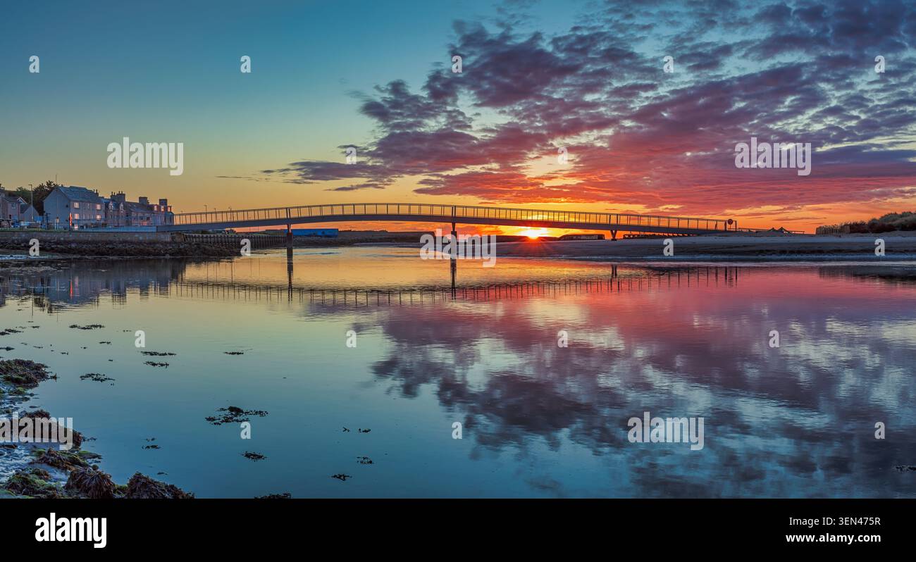Sommersonnenaufgang über der neuen Fußgängerbrücke von der Promenade zum Oststrand bei Lossiemouth am Moray Firth im Nordosten Schottlands Stockfoto