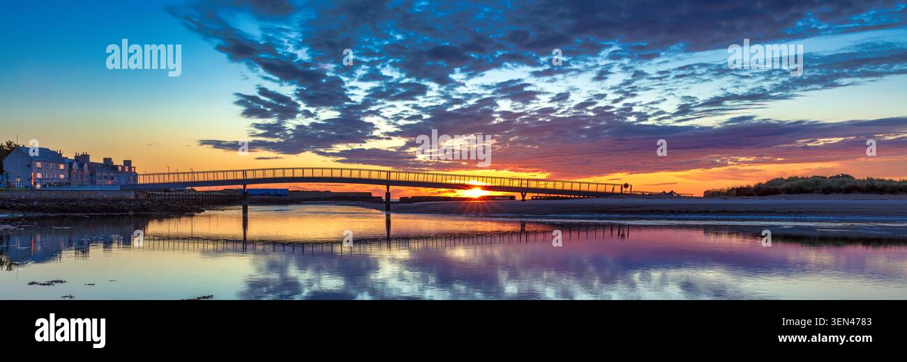 Sommersonnenaufgang über der neuen Fußgängerbrücke von der Promenade zum Oststrand bei Lossiemouth am Moray Firth im Nordosten Schottlands Stockfoto