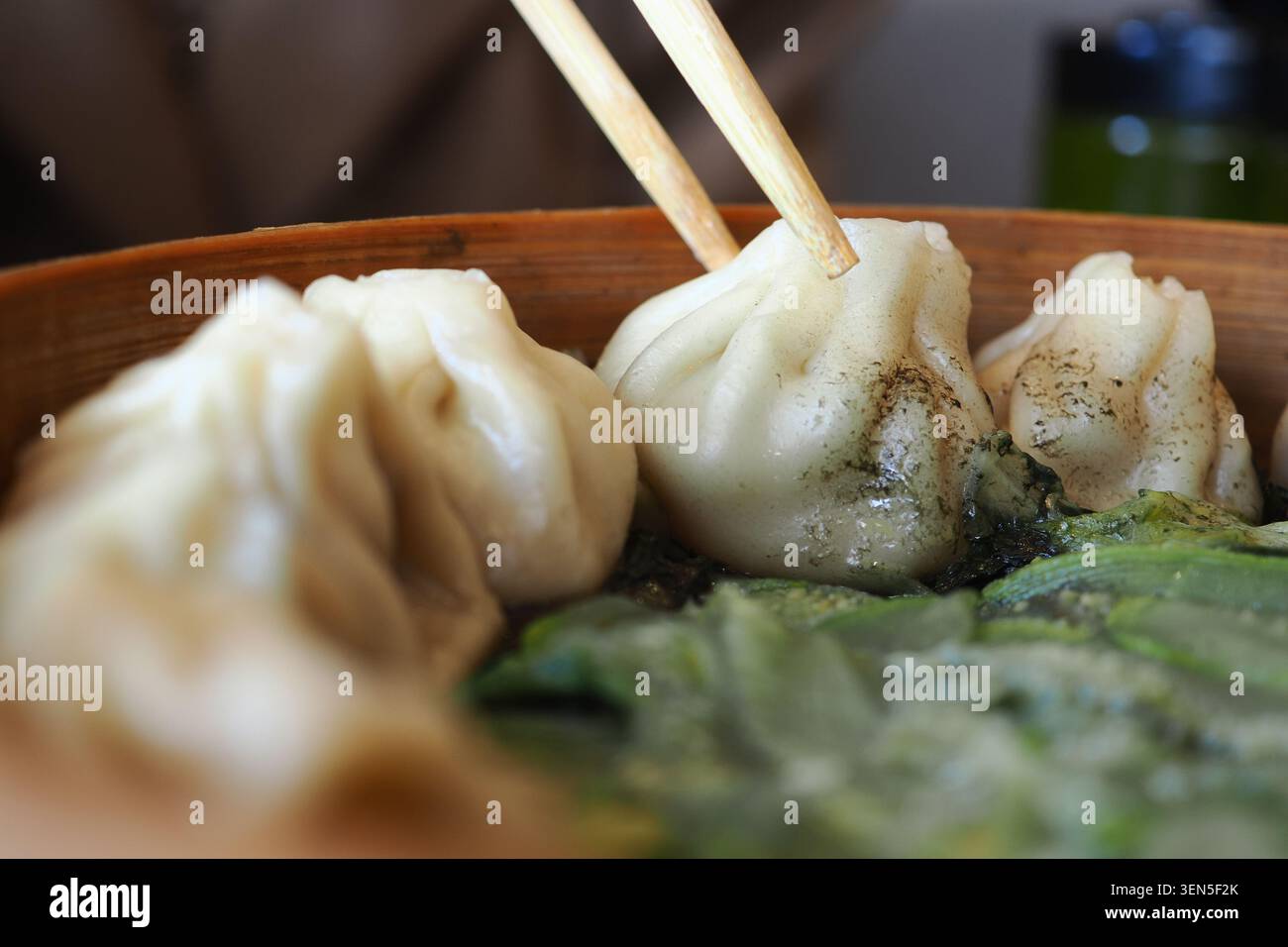 Knödel in einer Holzschale mit Essstäbchen serviert Stockfoto