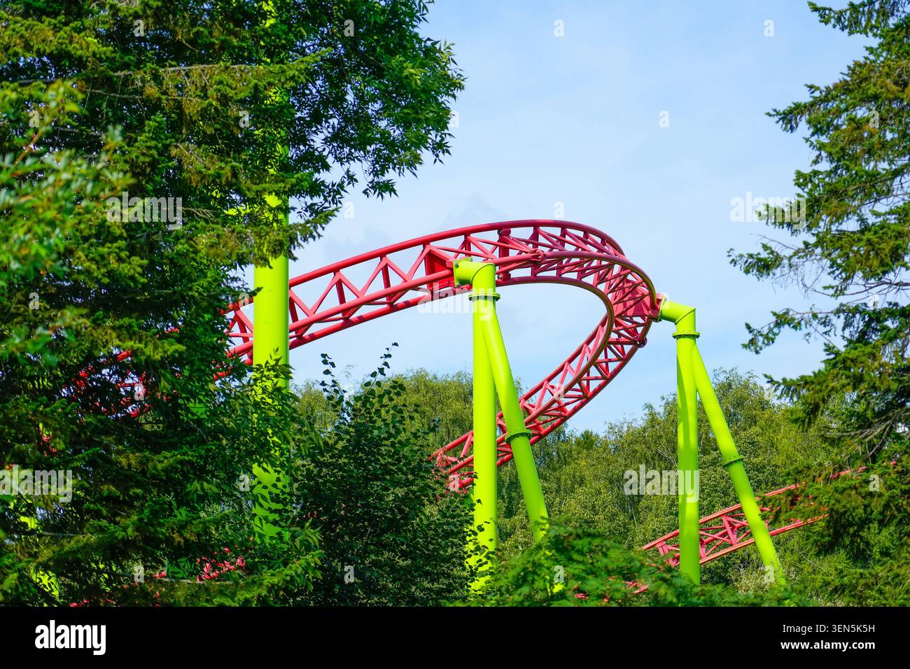Achterbahn nach oben und nach unten und eine vorbeifahrende Schleife fettt, Spirale neigt dazu, nach unten zu gehen Stockfoto