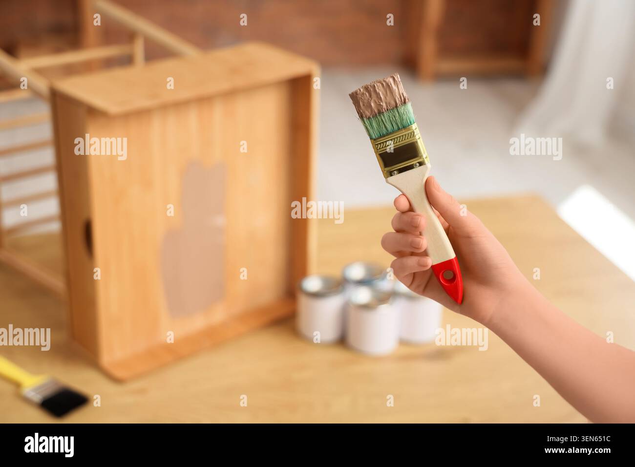 Handpinsel mit brauner Farbe, Heimwerkerprojekt, Renovierung von Möbeln, kreative Handarbeit Stockfoto