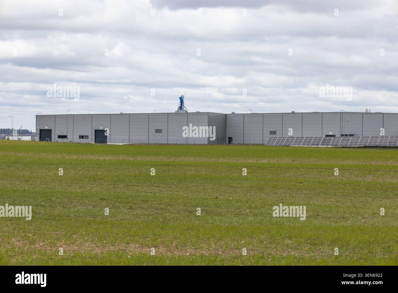 Modernes Industriehaus hinter einem grünen Grasfeld Stockfoto
