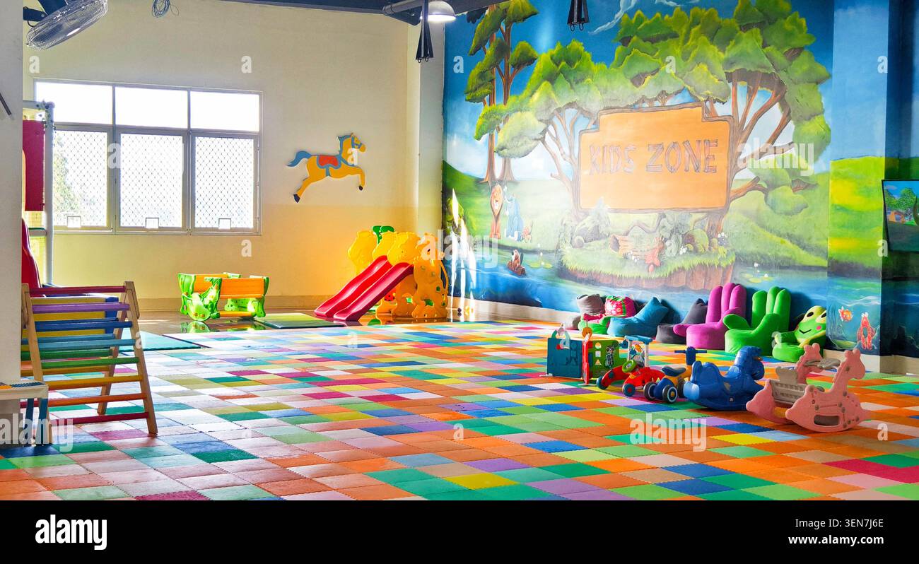 Helles Kinderspielzimmer mit Rutschen, Spielzeug und Wandgemälde Stockfoto