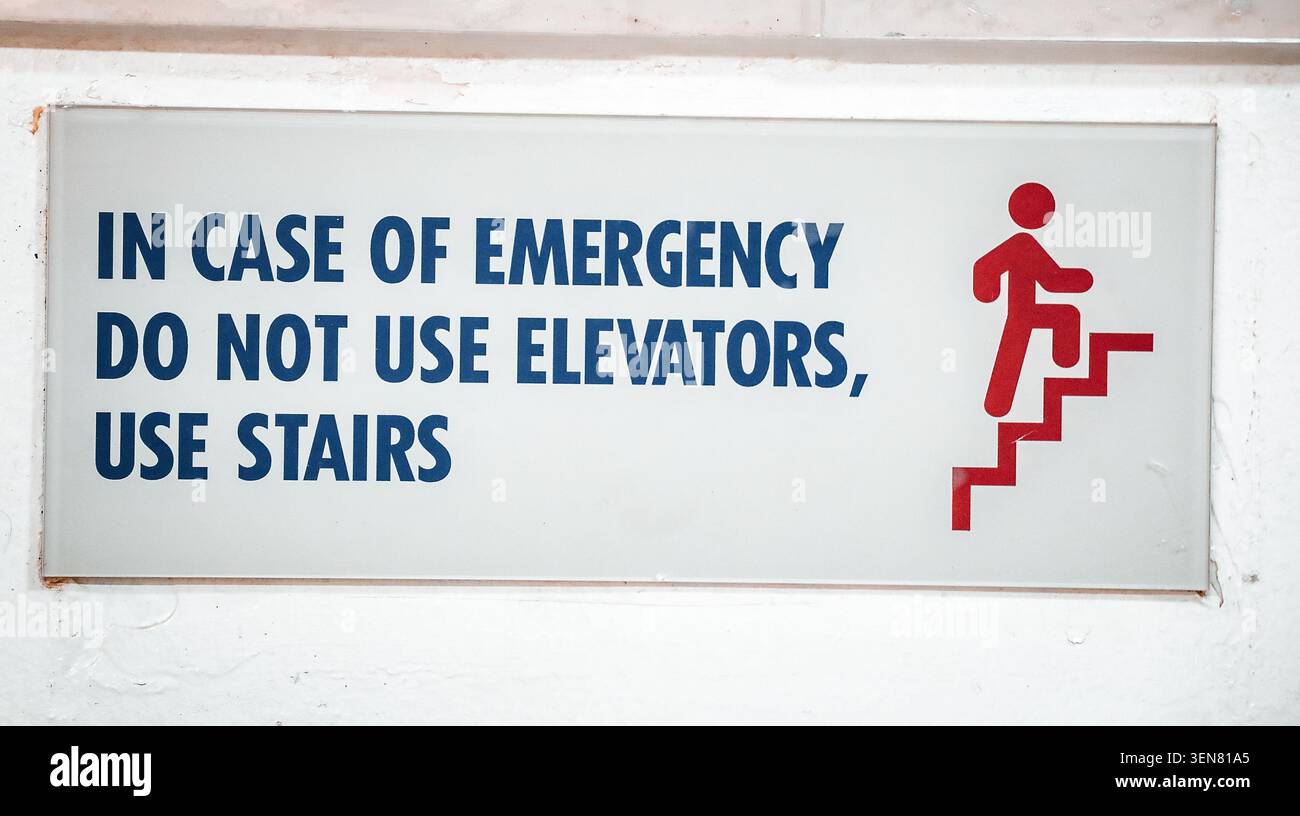 Sicherheitsschild für den Notfall an der Gebäudewand lesen im Notfall keine Aufzüge verwenden Treppen mit grafischem Symbol verwenden. Stockfoto