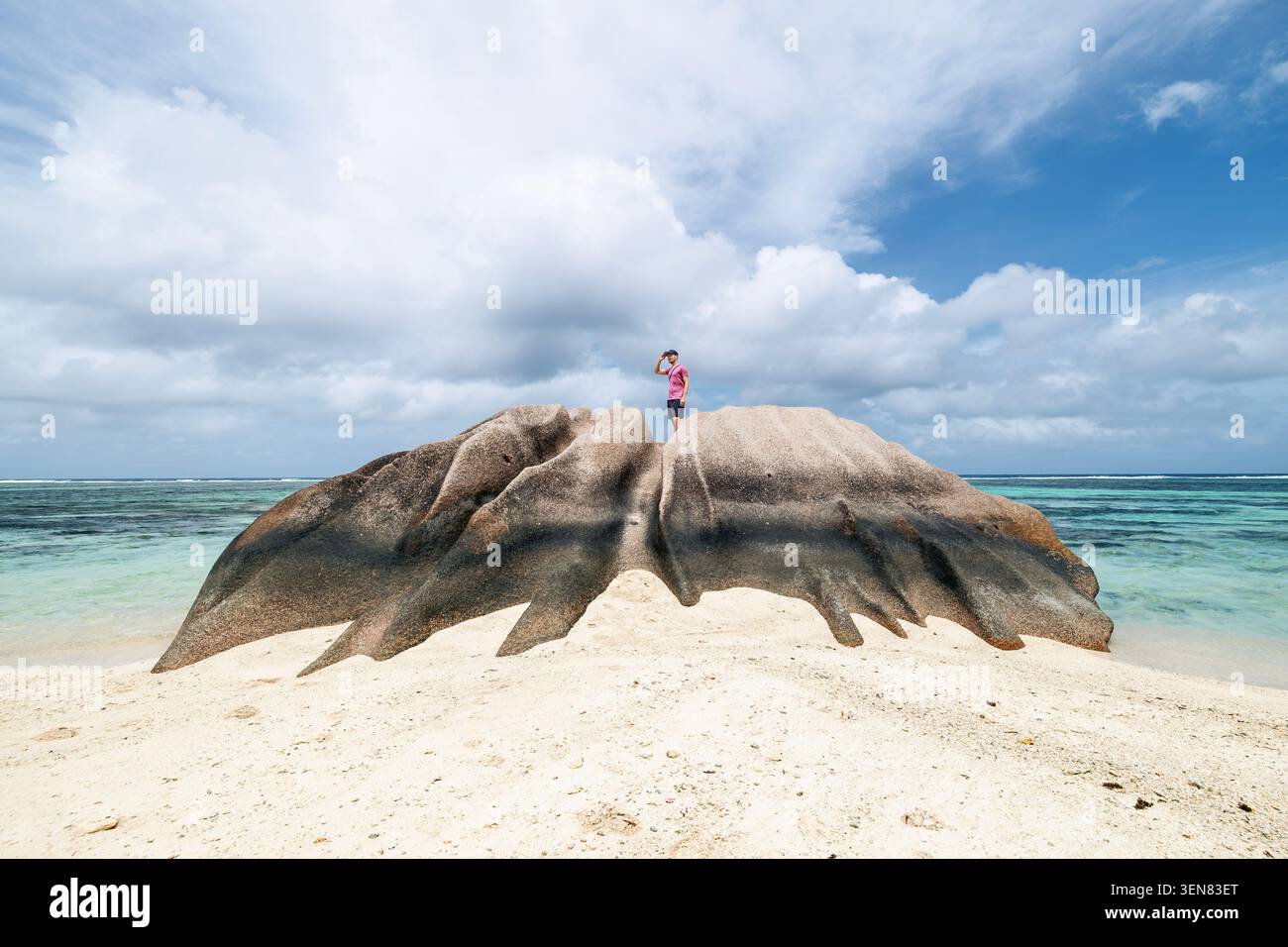 Touristen, die auf Granitfelsen auf den Seychellen stehen und sich am Horizont umsehen. Einsamkeit, Freiheit, Outdoor-Erkundung und Reiseziele im Vergleich Stockfoto