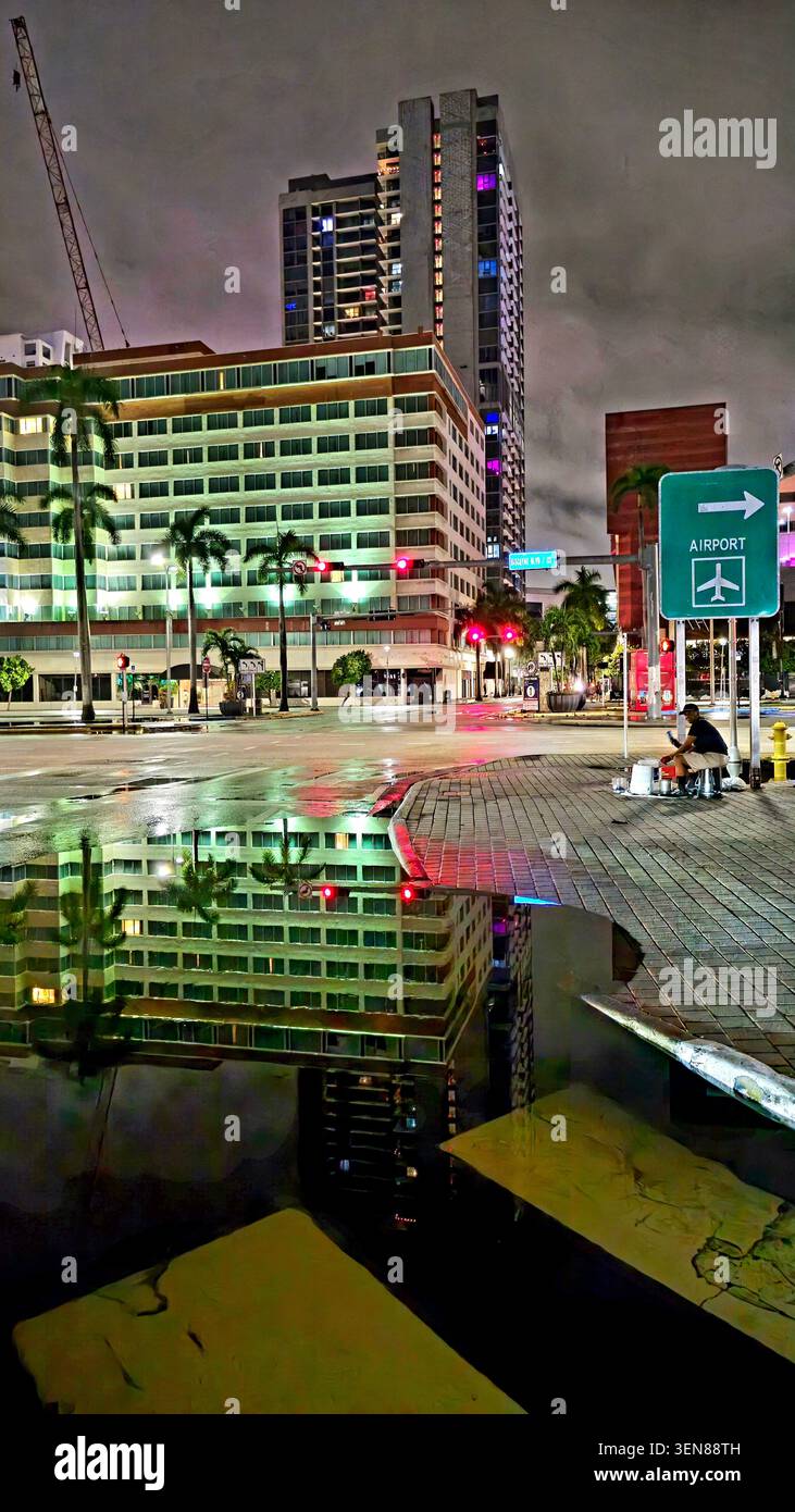 Downtown Miami nächtliche Stadtlandschaft mit Reflexionen auf nassen Straßen und Lichtern von Skyscapers - Smartphone-aufgenommenes Stockfoto