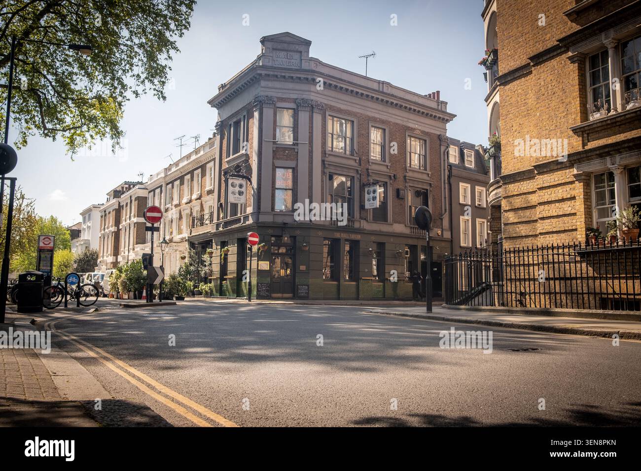LONDON - 23. APRIL 2026: DIE MALL TAVERN, PALACE GARDENS TERRACE – traditioneller Eckpub mit Sitzgelegenheiten im Freien auf der sonnigen London Street Stockfoto