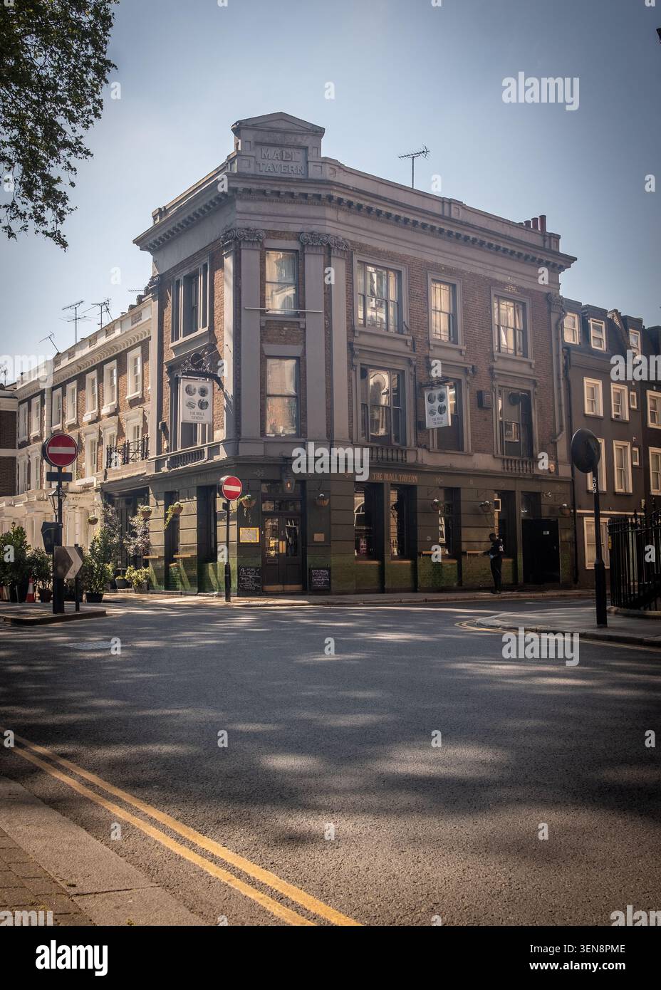 LONDON - 23. APRIL 2026: DIE MALL TAVERN, PALACE GARDENS TERRACE – traditioneller Eckpub mit Sitzgelegenheiten im Freien auf der sonnigen London Street Stockfoto